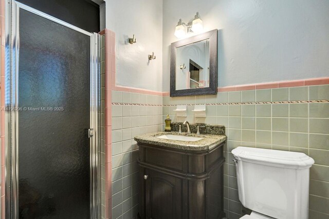 825 NE 98th St, Miami Shores, FL 33138 - bathroom with a stall shower, tile walls, a wainscoted wall, vanity, and toilet