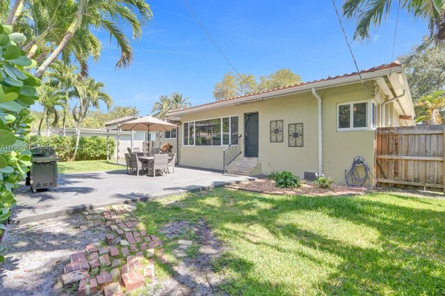 825 NE 98th St, Miami Shores, FL 33138 - rear view of property featuring entry steps, stucco siding, and a patio