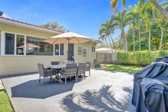 825 NE 98th St, Miami Shores, FL 33138 - view of patio / terrace with fence, outdoor dining space, and a grill
