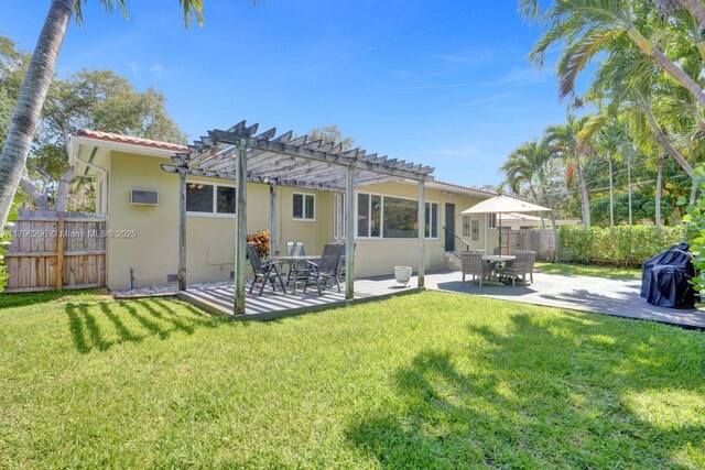 825 NE 98th St, Miami Shores, FL 33138 - back of property with a pergola, stucco siding, a patio, and a wall mounted air conditioner