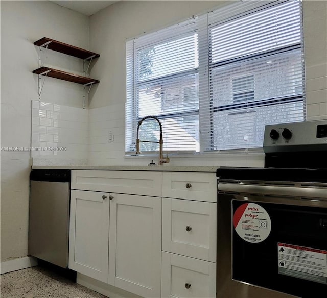1436 SW 3rd St, Miami, FL 33135 - kitchen with stainless steel appliances, dark speckled floor, white cabinets, decorative backsplash, and light countertops