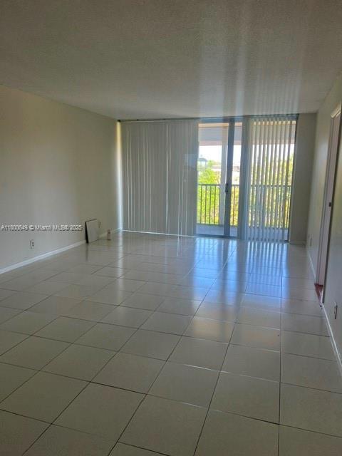 3801 Environ Blvd Unit 516, Lauderhill, FL 33319 - spare room featuring tile patterned floors, baseboards, and floor to ceiling windows