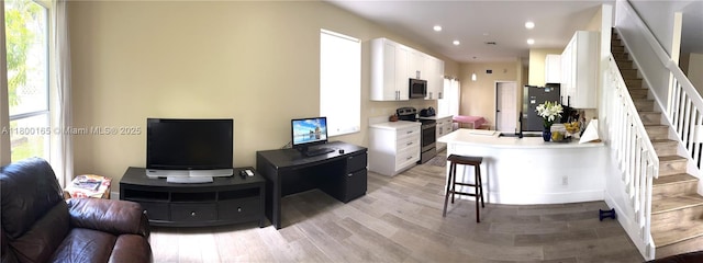 kitchen featuring appliances with stainless steel finishes, white cabinets, recessed lighting, light countertops, and light wood-style floors