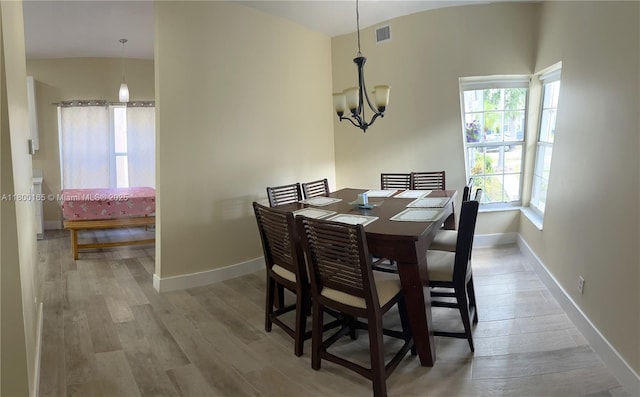 dining room with wood finished floors, a chandelier, and baseboards