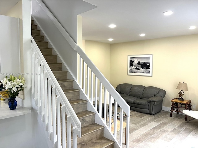 staircase with recessed lighting and wood finished floors