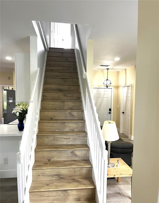 staircase with baseboards, recessed lighting, and wood finished floors