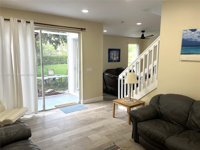 living area featuring recessed lighting, stairway, a ceiling fan, light wood finished floors, and baseboards