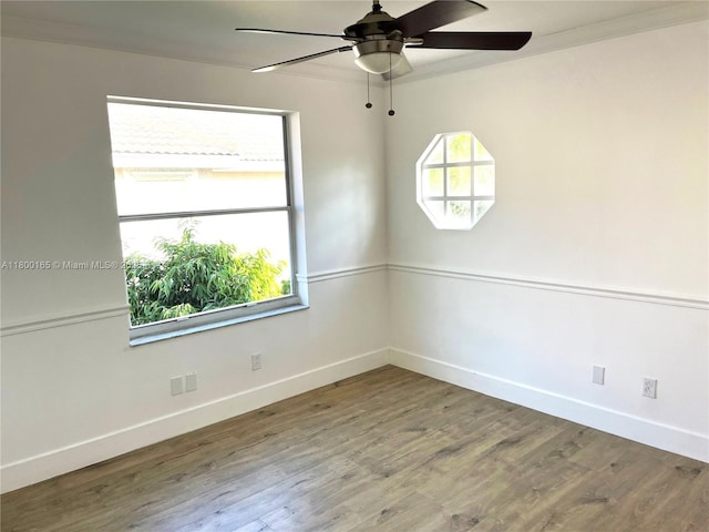 empty room featuring baseboards, plenty of natural light, a ceiling fan, and crown molding