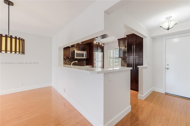 431 SE 3rd St Unit 201, Dania Beach, FL 33004 - kitchen with stainless steel appliances, light wood-style floors, light countertops, dark brown cabinetry, and baseboards