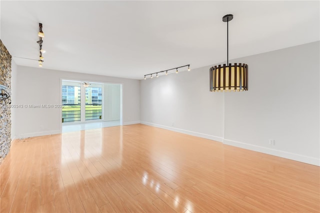 431 SE 3rd St Unit 201, Dania Beach, FL 33004 - unfurnished living room featuring rail lighting, light wood-style floors, and baseboards
