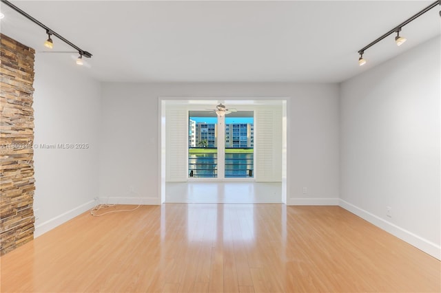 431 SE 3rd St Unit 201, Dania Beach, FL 33004 - empty room featuring track lighting, ceiling fan, wood finished floors, and baseboards
