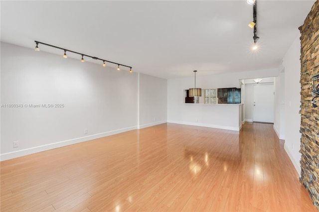 431 SE 3rd St Unit 201, Dania Beach, FL 33004 - unfurnished living room featuring track lighting, light wood finished floors, and baseboards