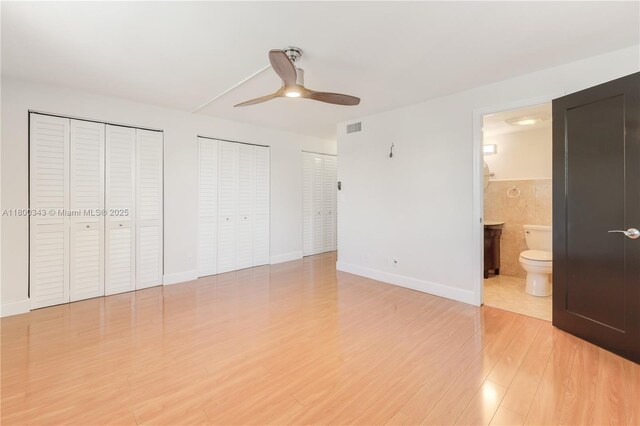 431 SE 3rd St Unit 201, Dania Beach, FL 33004 - unfurnished bedroom with multiple closets, light wood-style flooring, ensuite bath, baseboards, and a ceiling fan