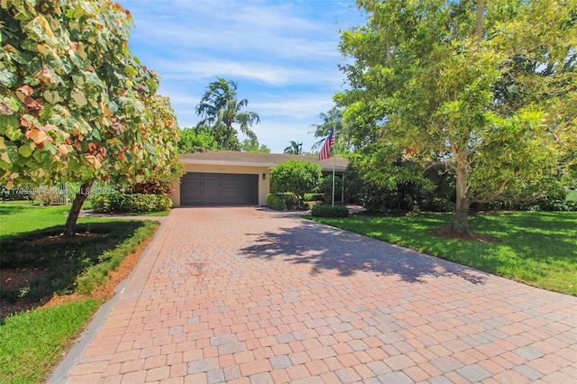 8345 SW 143rd St, Palmetto Bay, FL 33158 - view of front of house featuring decorative driveway, a front yard, stucco siding, and an attached garage