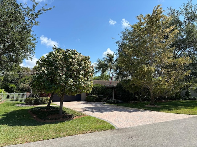 obstructed view of property with a garage and decorative driveway