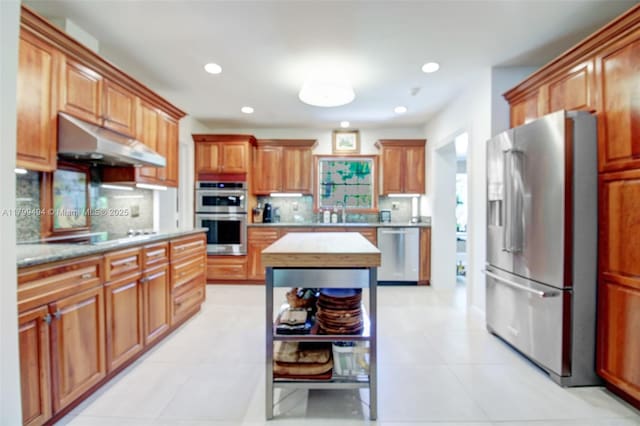 8345 SW 143rd St, Palmetto Bay, FL 33158 - kitchen featuring stainless steel appliances, under cabinet range hood, recessed lighting, tasteful backsplash, and brown cabinets