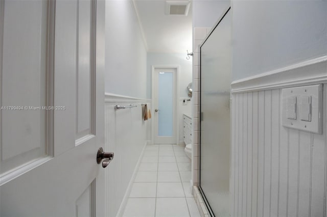 8345 SW 143rd St, Palmetto Bay, FL 33158 - bathroom featuring tile patterned floors, a shower stall, wainscoting, and a decorative wall