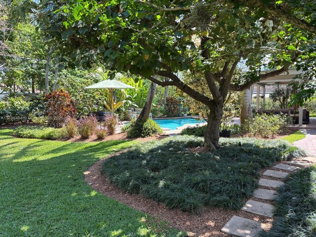 view of green lawn with an outdoor pool