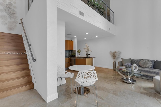 living area with baseboards, stairway, a towering ceiling, and recessed lighting