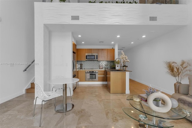kitchen featuring appliances with stainless steel finishes, baseboards, tasteful backsplash, recessed lighting, and a sink