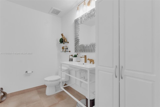 bathroom with toilet, baseboards, and a sink