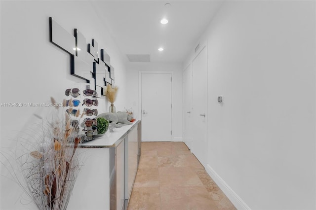 hall featuring recessed lighting and baseboards