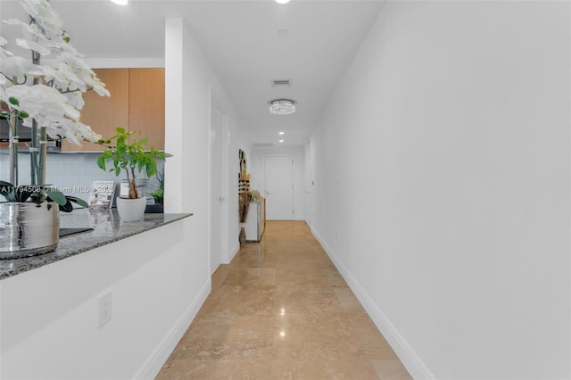 corridor featuring baseboards, recessed lighting, and light marble finish flooring