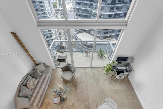 unfurnished living room featuring an office area, baseboards, and a city view