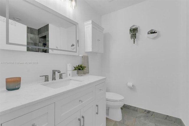 bathroom featuring baseboards, toilet, vanity, and a shower