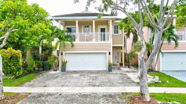 377 NE 34th Ter, Homestead, FL 33033 - view of front facade with decorative driveway, an attached garage, a balcony, and stucco siding