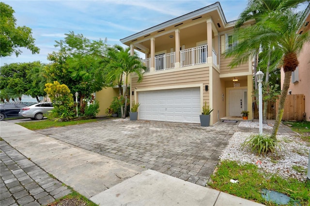 377 NE 34th Ter, Homestead, FL 33033 - view of front of home with a balcony, an attached garage, stucco siding, and decorative driveway