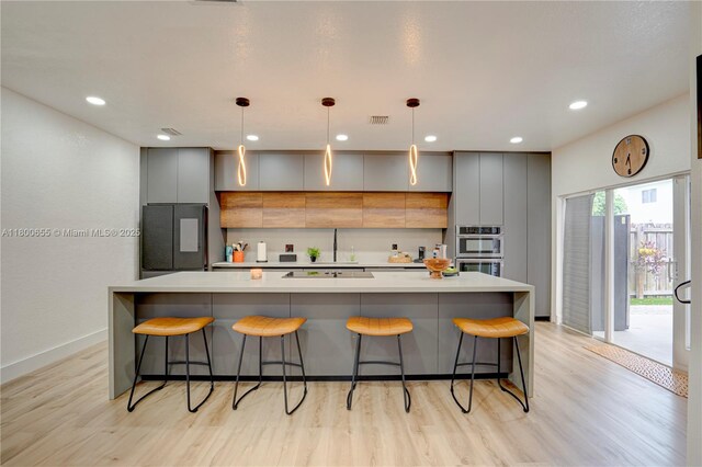 377 NE 34th Ter, Homestead, FL 33033 - kitchen with black appliances, gray cabinetry, light wood-type flooring, light countertops, and recessed lighting