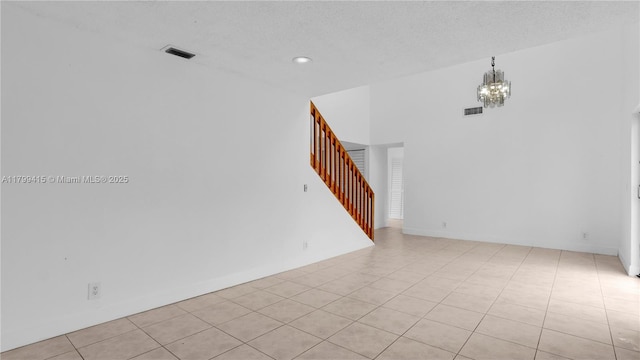 unfurnished room with stairs, a chandelier, light tile patterned floors, recessed lighting, and a textured ceiling