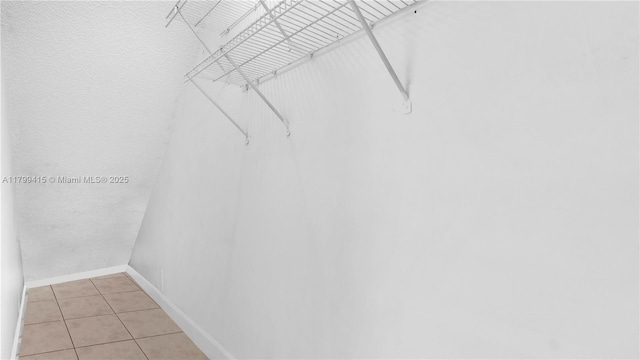 spacious closet with light tile patterned floors