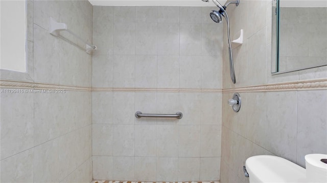 bathroom featuring a tile shower and toilet