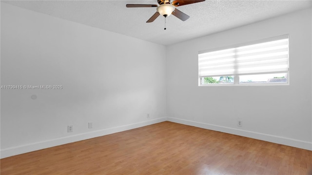 unfurnished room with ceiling fan, light wood finished floors, baseboards, and a textured ceiling
