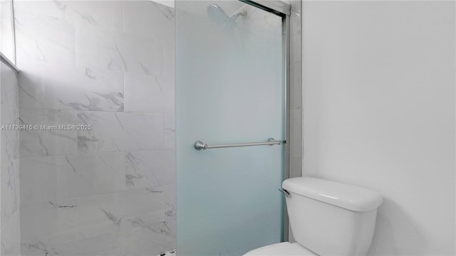 full bath featuring a shower stall and toilet