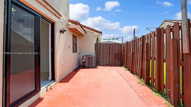 view of patio / terrace featuring central AC unit and fence