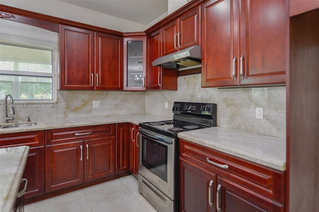 611 SW 8th St, Hallandale Beach, FL 33009 - kitchen with reddish brown cabinets, electric range, under cabinet range hood, a sink, and backsplash