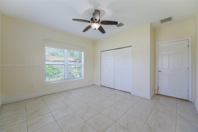 611 SW 8th St, Hallandale Beach, FL 33009 - unfurnished bedroom with a closet, light tile patterned floors, ceiling fan, and baseboards