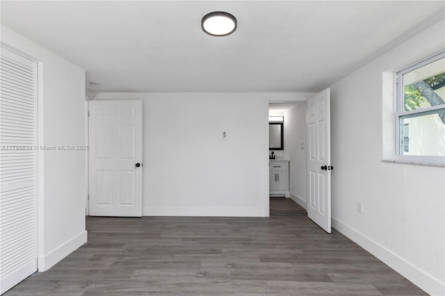 unfurnished bedroom with baseboards and wood finished floors