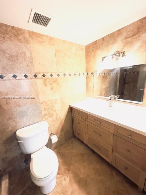 4200 Hillcrest Dr Unit 1017, Hollywood, FL 33021 - bathroom featuring vanity, toilet, tile walls, and tile patterned flooring
