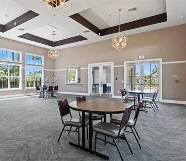 4200 Hillcrest Dr Unit 1017, Hollywood, FL 33021 - dining room featuring french doors, a chandelier, baseboards, a tray ceiling, and a towering ceiling
