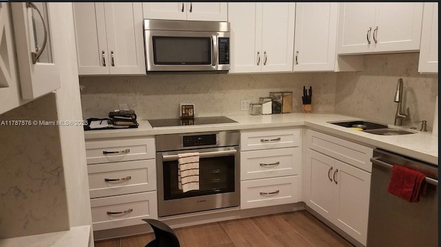 4200 Hillcrest Dr Unit 1017, Hollywood, FL 33021 - kitchen with stainless steel appliances, a sink, white cabinetry, light countertops, and light wood finished floors