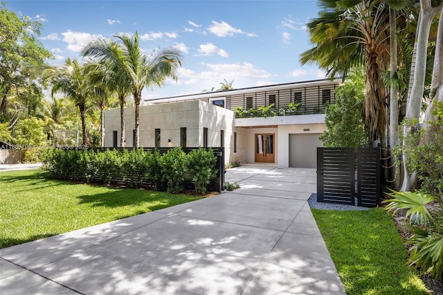 2905 Washington St, Miami, FL 33133 - contemporary house featuring concrete driveway, a garage, a front yard, stucco siding, and a balcony