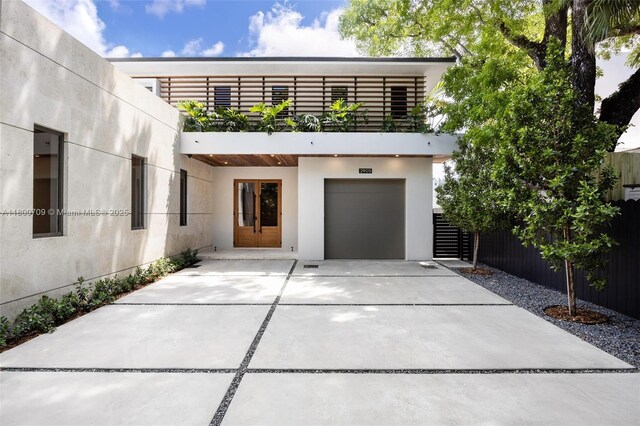 2905 Washington St, Miami, FL 33133 - view of front of house featuring a garage, stucco siding, driveway, and fence