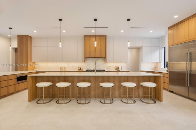 2905 Washington St, Miami, FL 33133 - kitchen with modern cabinets, built in refrigerator, light countertops, backsplash, and a large island