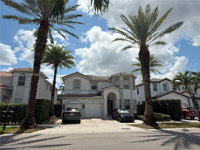 8389 NW 115th Ct, Doral, FL 33178 - mediterranean / spanish home featuring driveway, a garage, stucco siding, and a tile roof