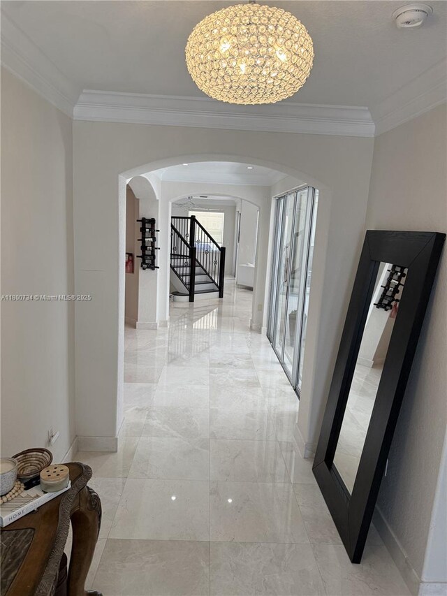 8389 NW 115th Ct, Doral, FL 33178 - hallway featuring arched walkways, light marble finish floors, crown molding, a chandelier, and stairs