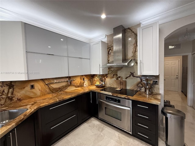 8389 NW 115th Ct, Doral, FL 33178 - kitchen with stainless steel oven, black electric stovetop, wall chimney exhaust hood, dark cabinetry, and white cabinetry